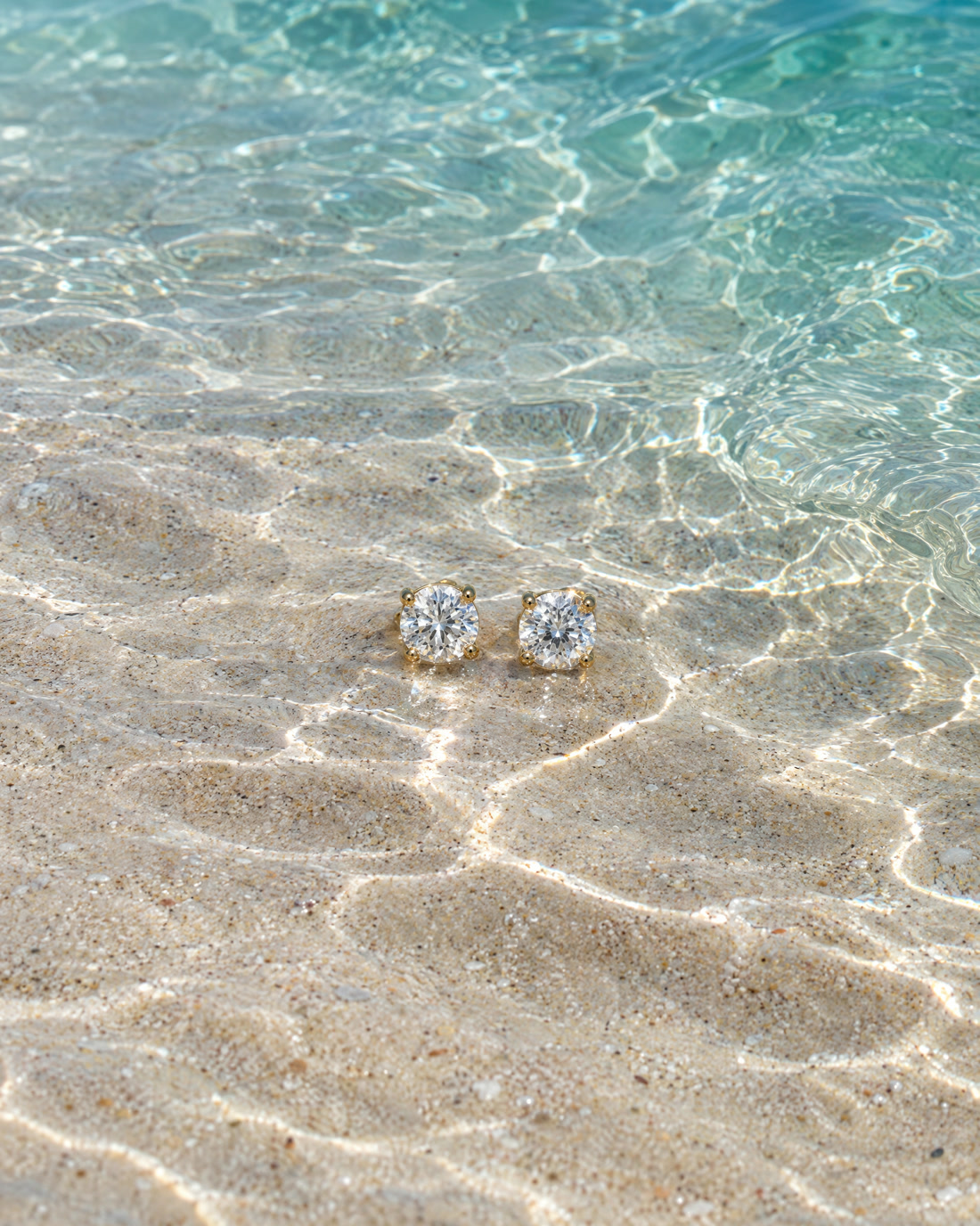 The Facet Studs, a pair of gold and platinum stud earrings.